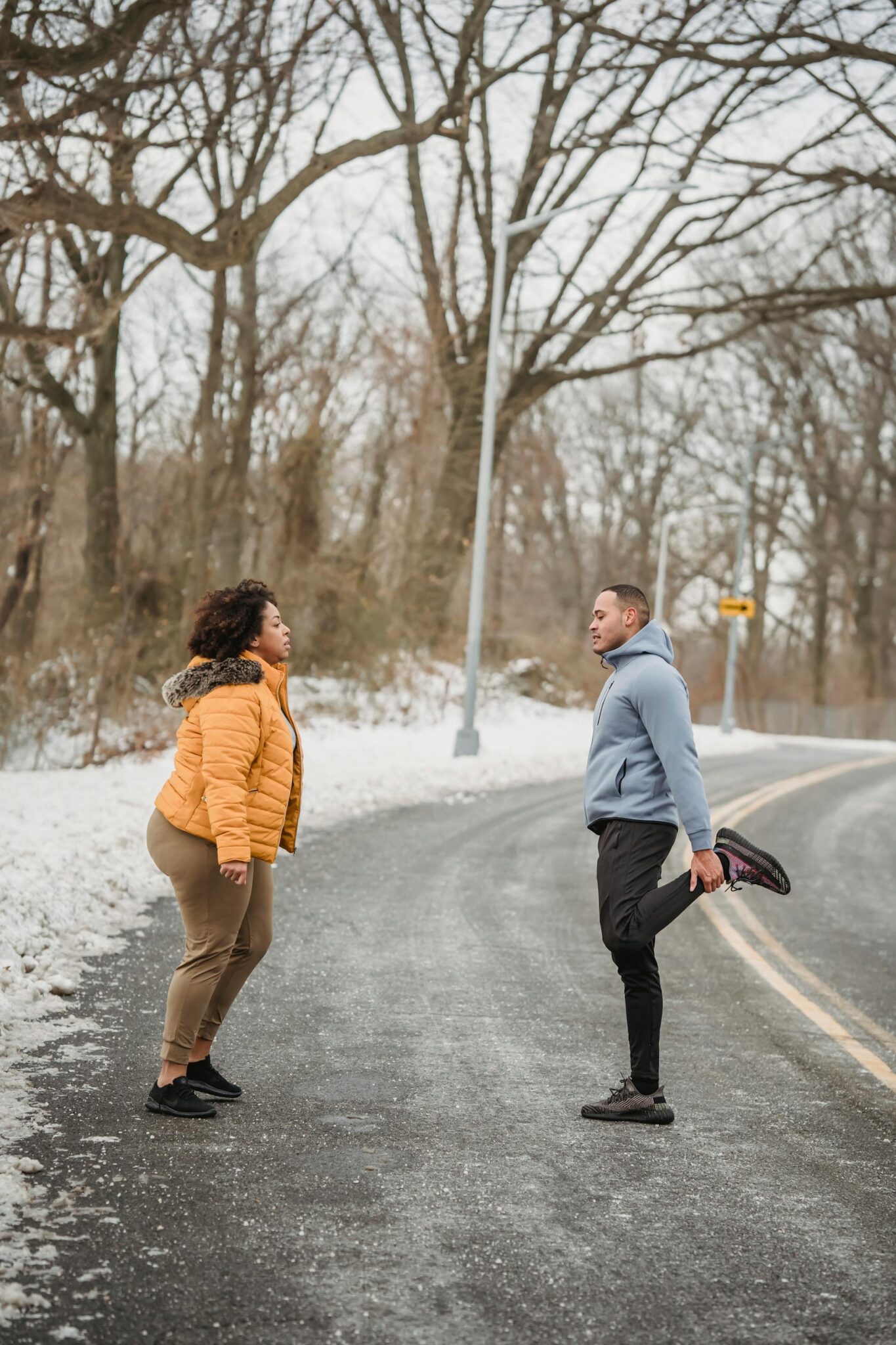 Žmonės sportuoja lauke žiemą apsirengę šiltai