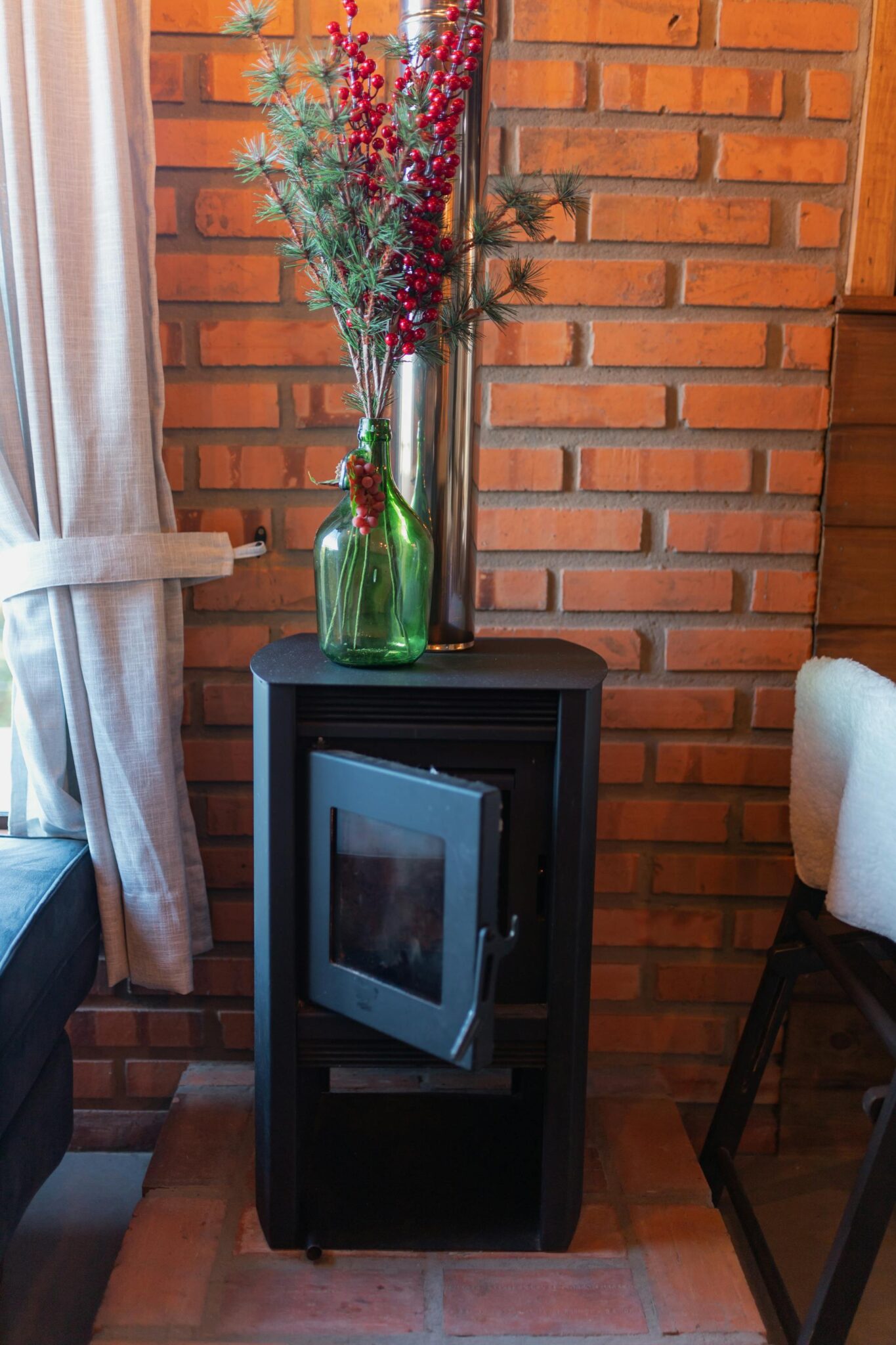 Moderni krosnelė jaukiame svetainės interjere su degančia ugnimi.